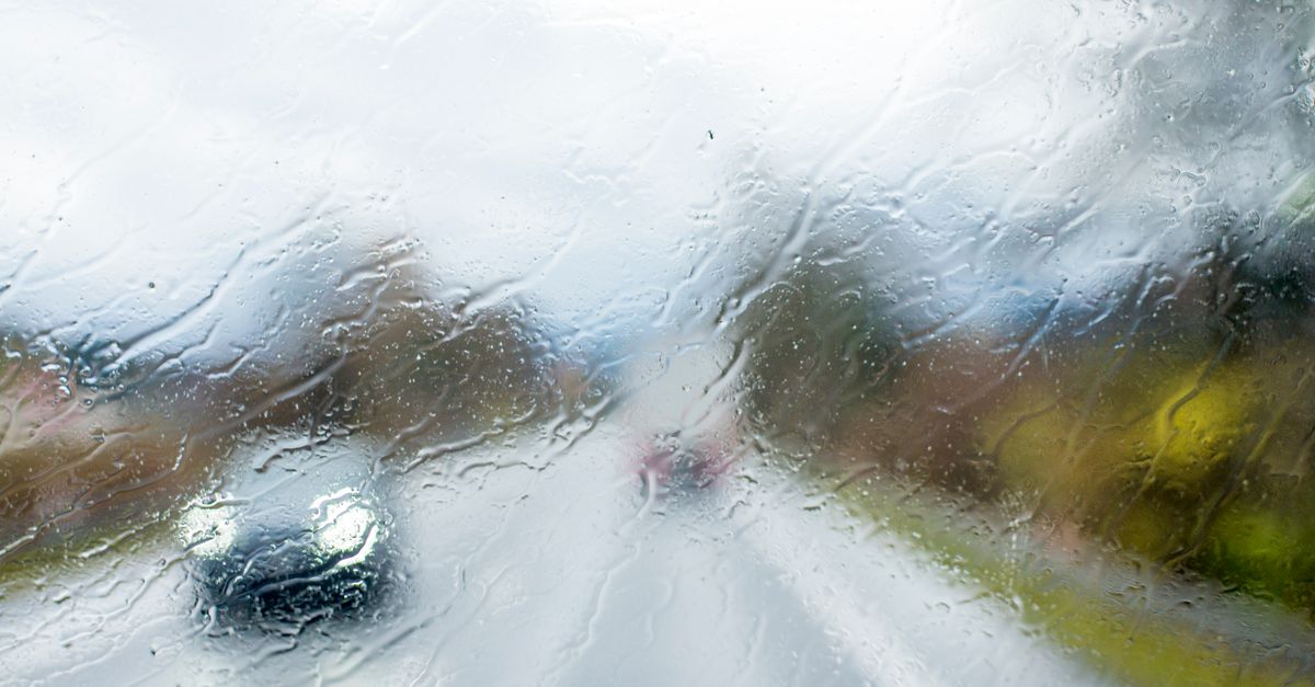 雨の日にワイパーが水滴を拭き取る車のフロントガラス