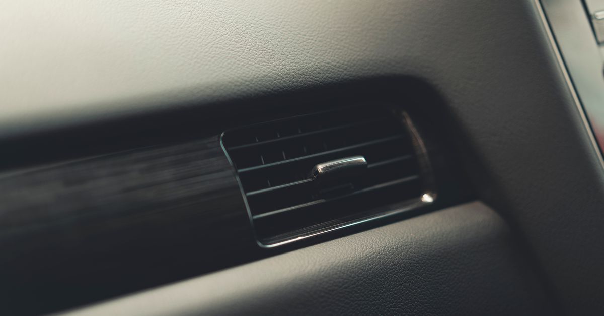 車内のエアコン吹き出し口を清掃している様子