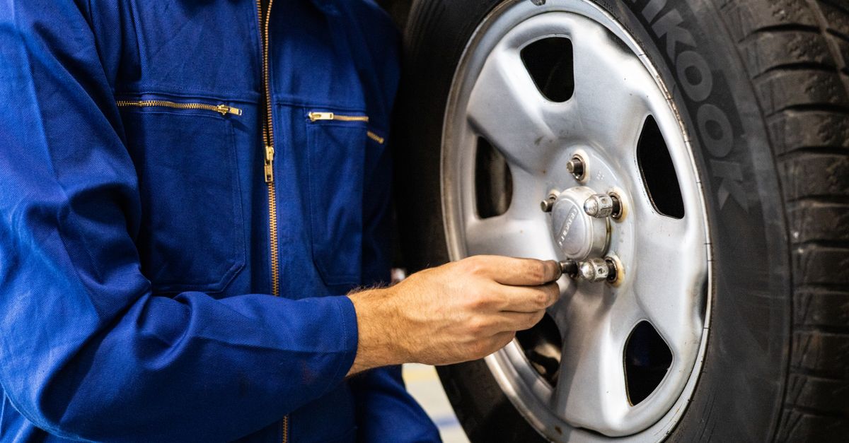 整備工場で車のタイヤやブレーキ周辺を点検する様子